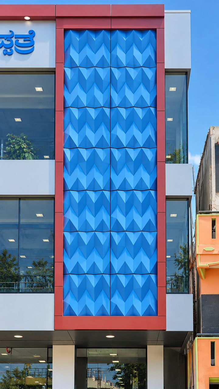 Commercial building with a full-height feature panel of blue faceted 3D ACP framed in red